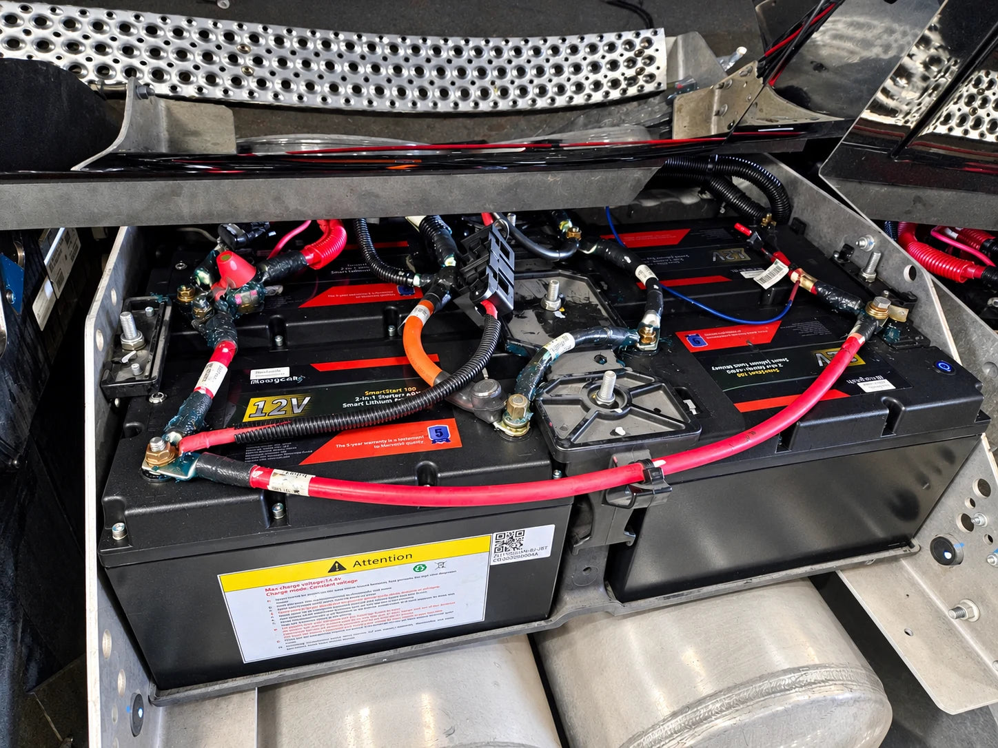 Dual-purpose batteries and connected cabling in a metal truck battery tray